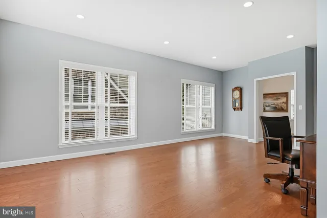 a living room with furniture hard wood floor and a table