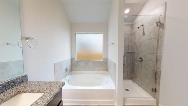 a bathroom with a granite countertop bathtub shower and toilet
