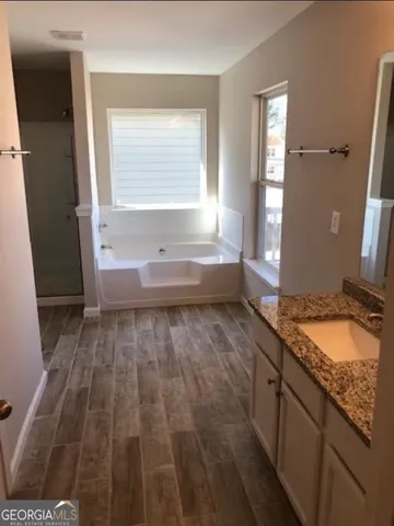 a spacious bathroom with a granite countertop sink and a mirror
