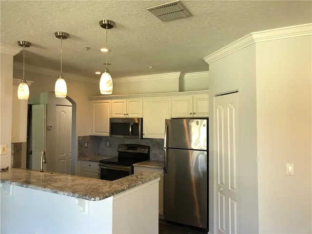 a kitchen with a refrigerator a microwave and sink