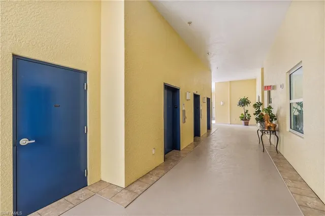 a view of hallway with furniture and a chandelier