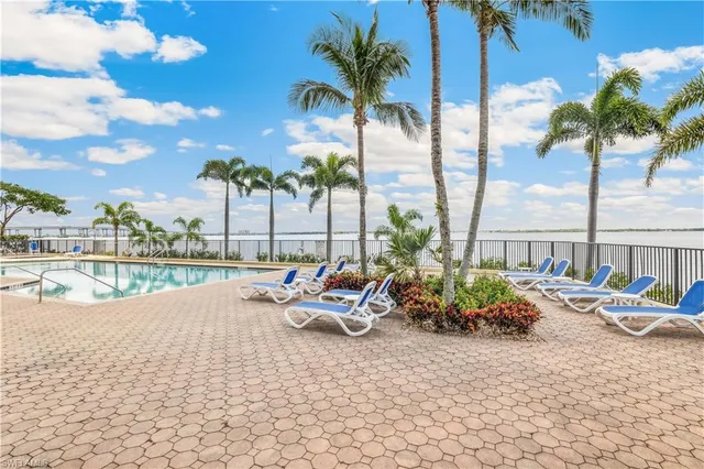 a row of palm trees and swimming pool in the backyard of a house