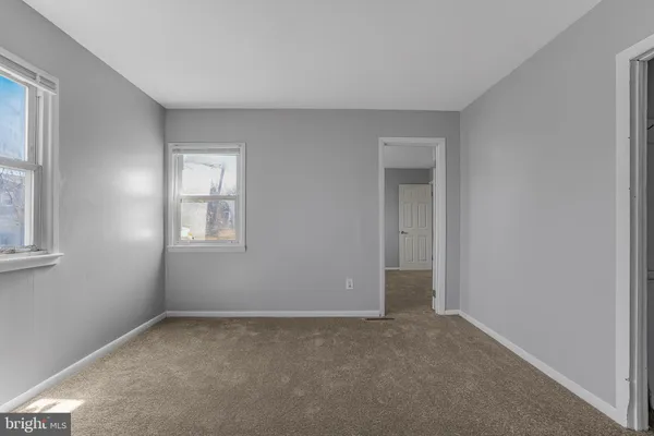 an empty room with windows and closet
