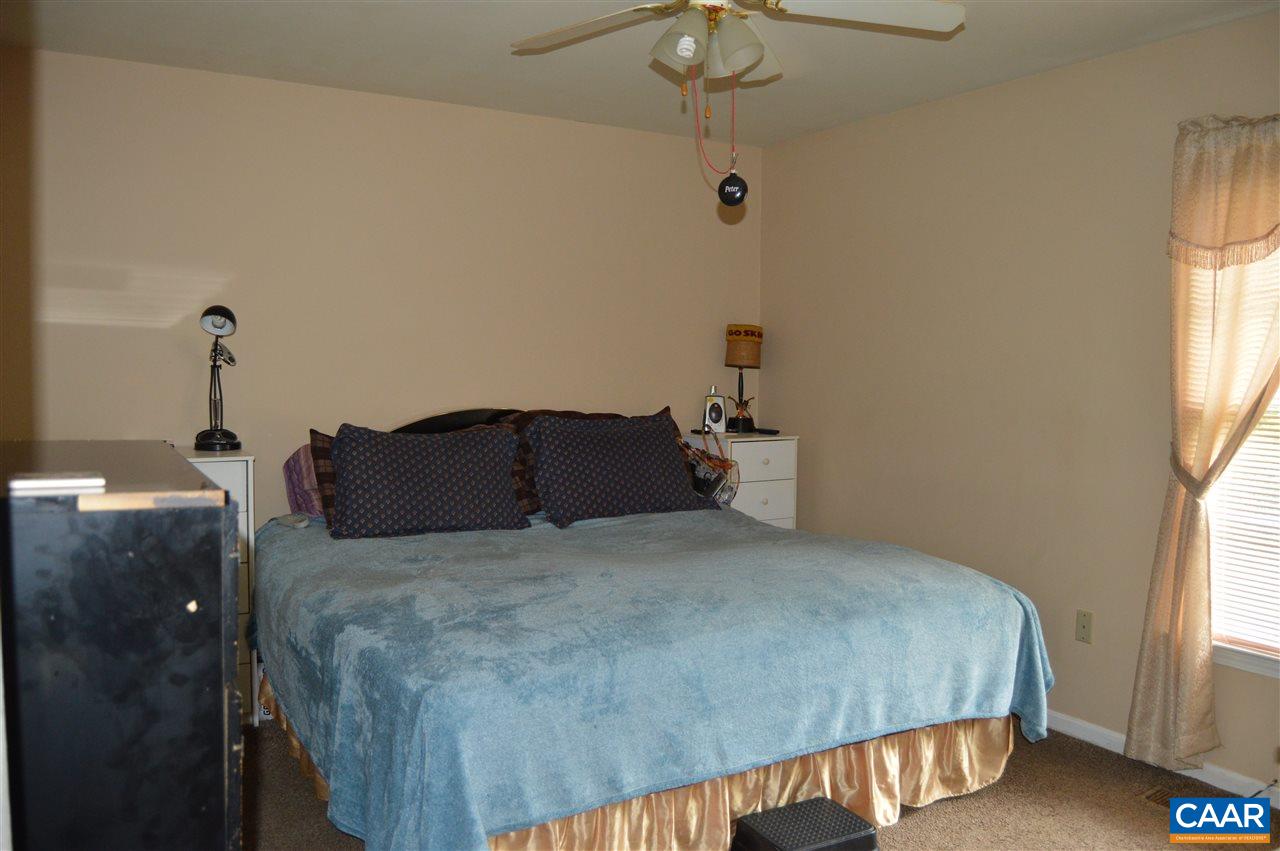 92 Rippin Run Road Ruckersville, VA 22968 - Photo 10 of 17 a bedroom with a bed and a chandelier