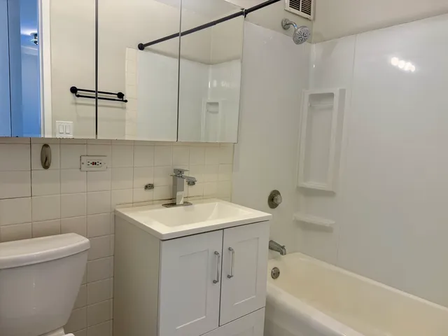 a bathroom with a sink toilet vanity and shower