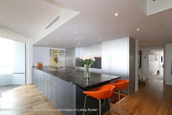 a kitchen with stainless steel appliances kitchen island a table and chairs in it