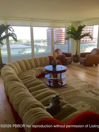 a living room with furniture large window and a table