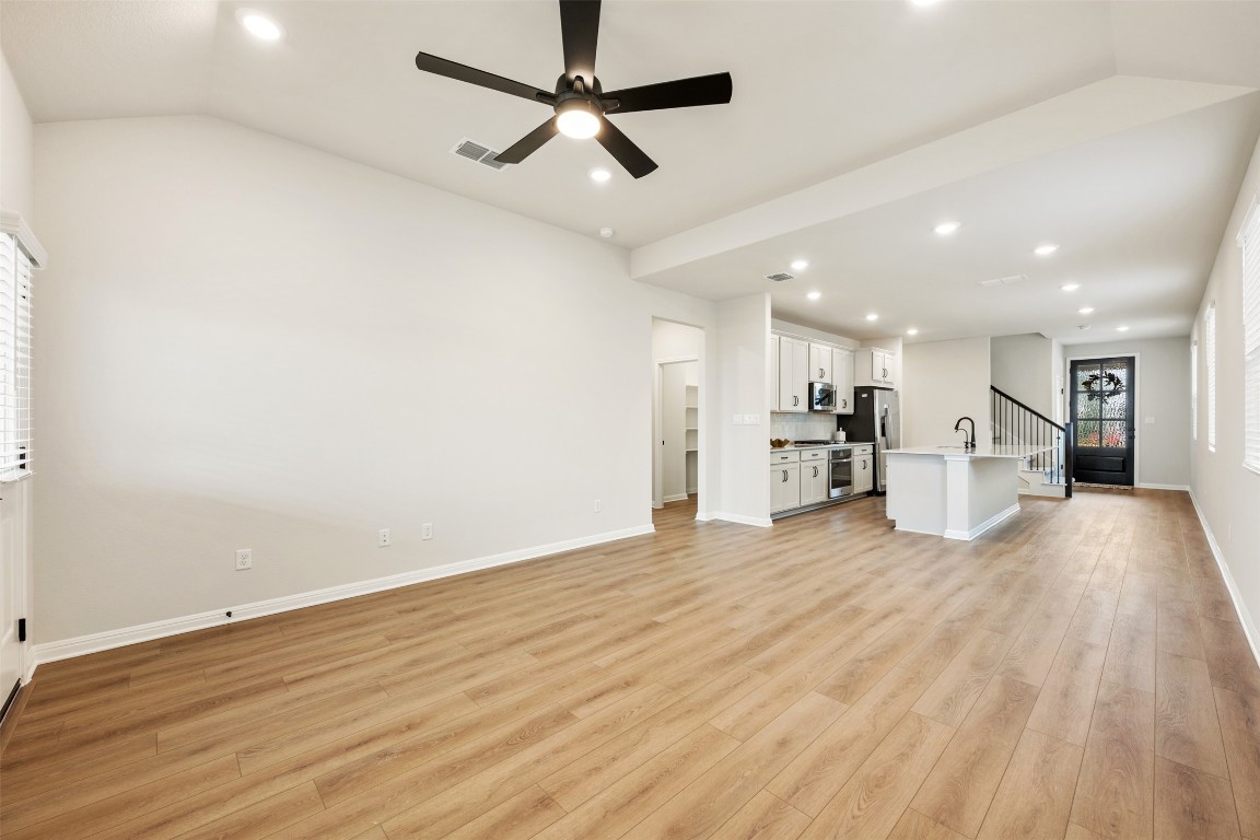 283 Ranier Way Dripping Springs, TX 78620 - Photo 15 of 39 Unfurnished living room with stairs, recessed lighting, light wood finished floors, ceiling fan, and lofted ceiling