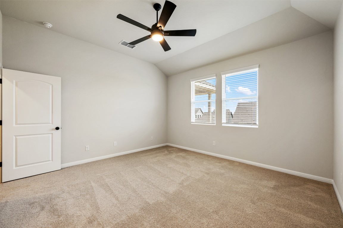 283 Ranier Way Dripping Springs, TX 78620 - Photo 20 of 39 Spare room featuring vaulted ceiling, light colored carpet, and ceiling fan