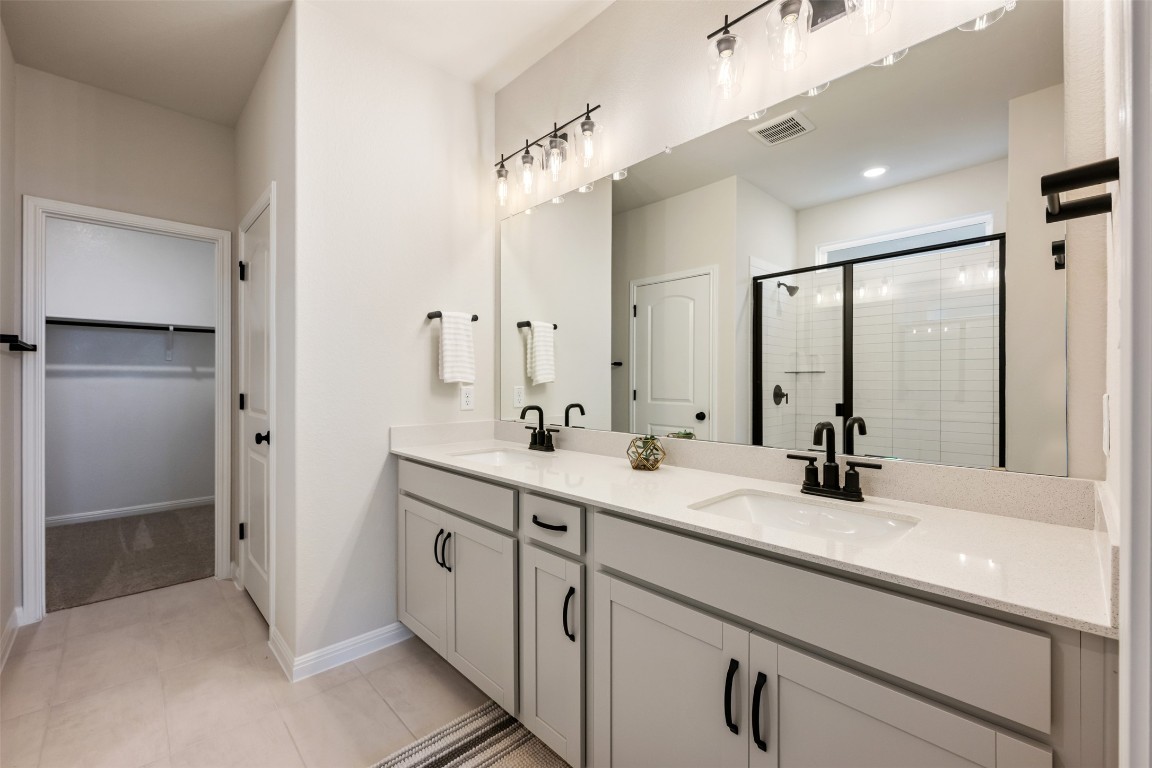 283 Ranier Way Dripping Springs, TX 78620 - Photo 22 of 39 Bathroom featuring double vanity, a shower stall, a spacious closet, and light tile patterned floors