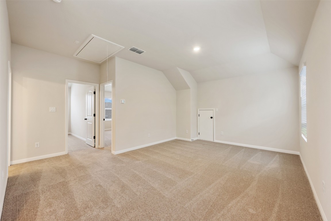 283 Ranier Way Dripping Springs, TX 78620 - Photo 30 of 39 Additional living space with attic access, light colored carpet, and vaulted ceiling