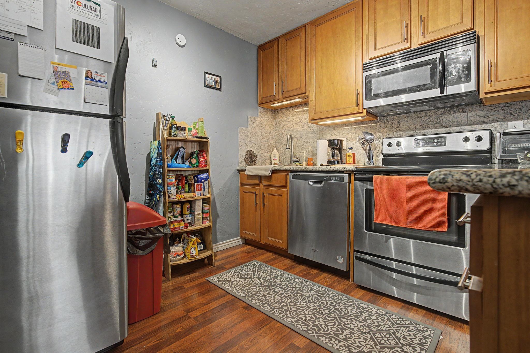 948 Northern Way, Unit 4 Grand Junction, CO 81506 - Photo 8 of 14 a kitchen with stainless steel appliances granite countertop a refrigerator and wooden cabinets