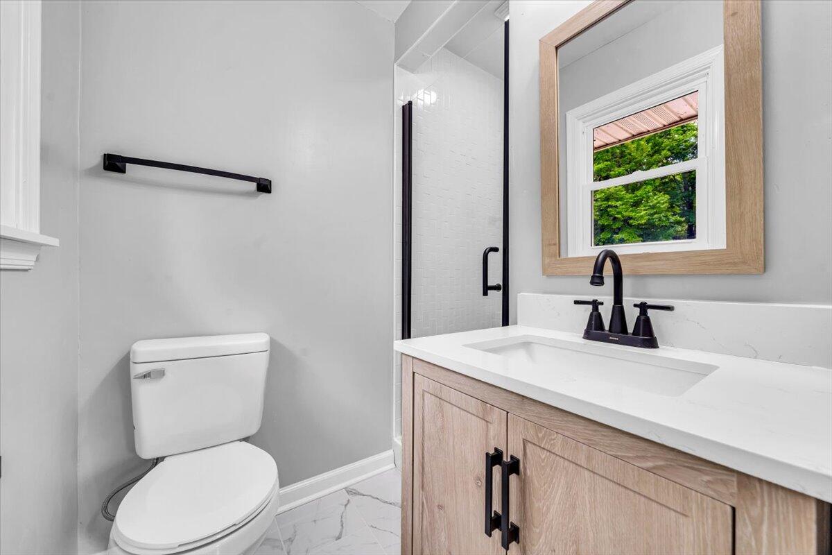233 Oak Drive Blue Ridge, VA 24064 - Photo 17 of 37 a bathroom with a toilet a sink and a window