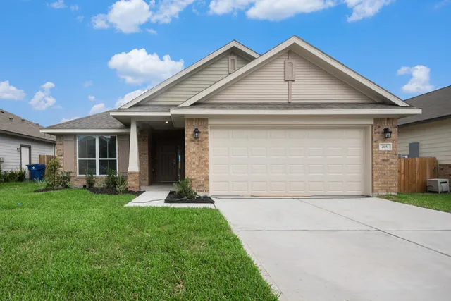 a front view of a house with a yard and garage