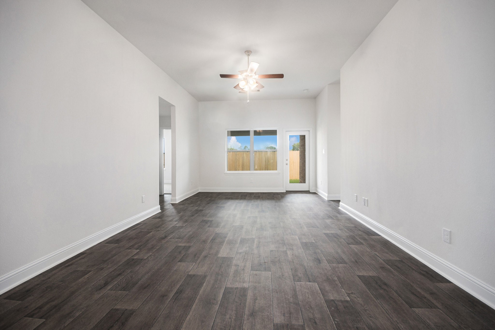 204 Bryan Way Angleton, TX 77515 - Photo 5 of 19 an empty room with wooden floor chandelier fan and windows