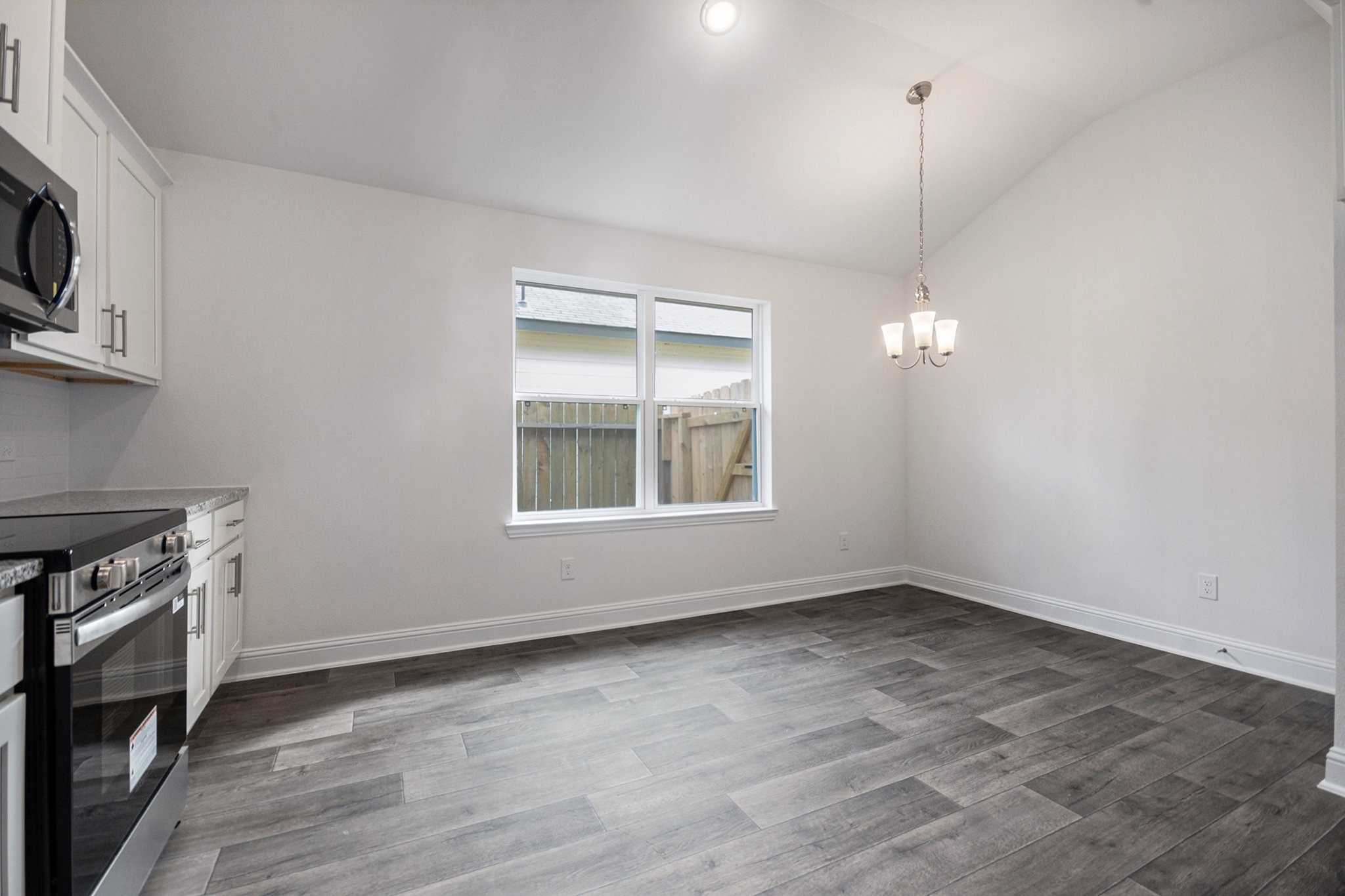 204 Bryan Way Angleton, TX 77515 - Photo 9 of 19 a view of an empty room with a window and wooden floor
