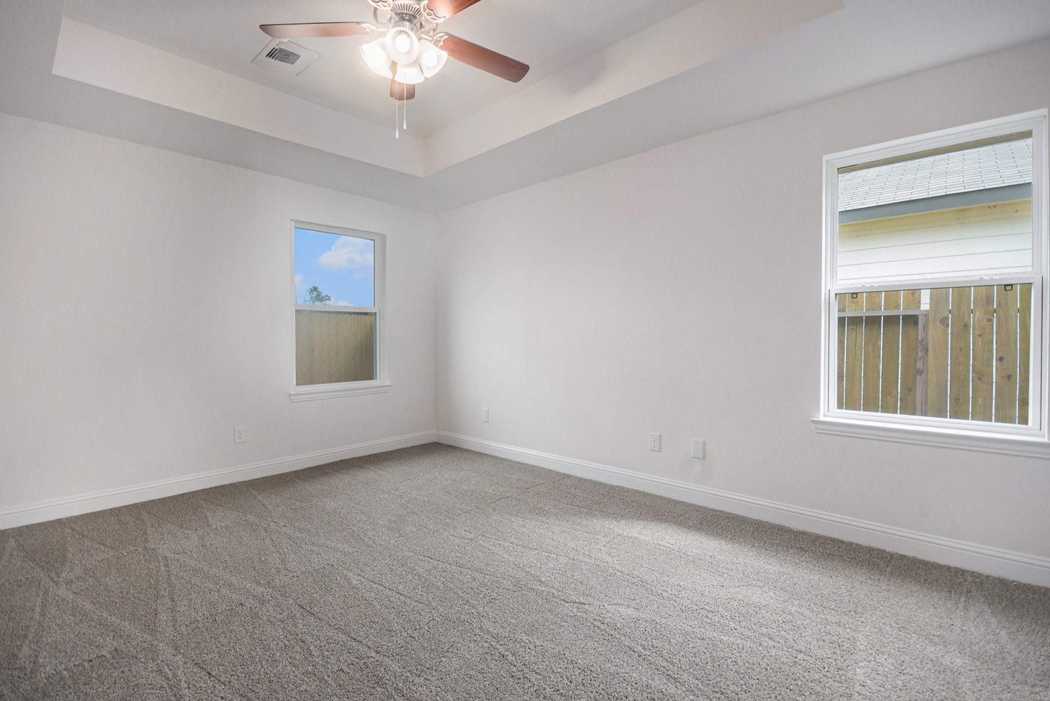 204 Bryan Way Angleton, TX 77515 - Photo 10 of 19 an empty room with a chandelier fan and windows