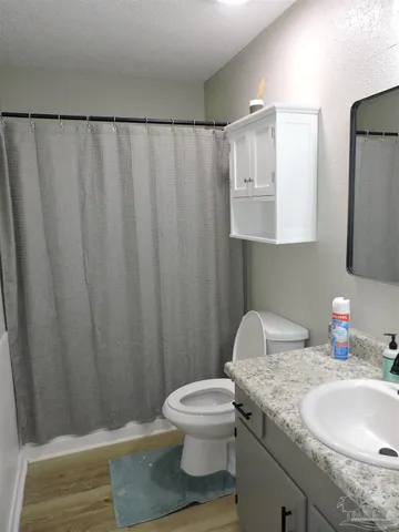 a bathroom with a granite countertop sink and a toilet