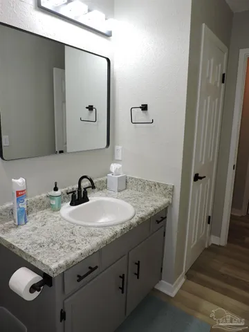 a bathroom with a granite countertop sink and a mirror