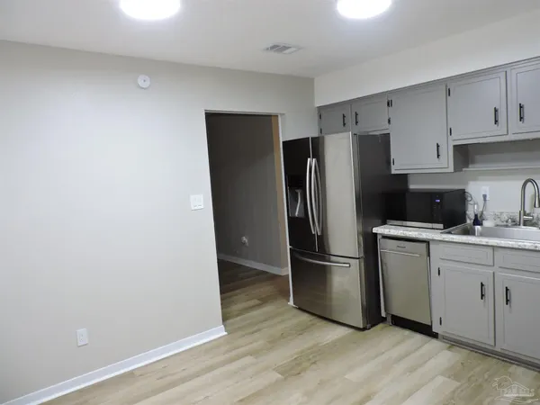 a kitchen with stainless steel appliances granite countertop a refrigerator and a stove