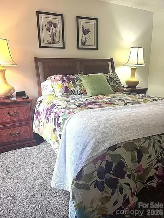 a bedroom with a bed and a painting on the wall