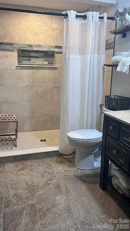 a bath room with a toilet and a shower