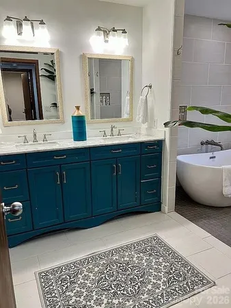 a bathroom with a tub sink and mirror