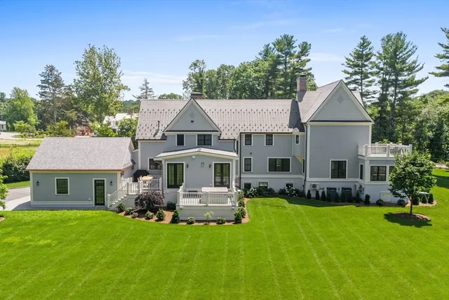 a front view of a house with a yard and trees