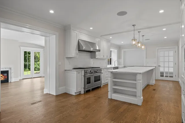 a large kitchen with stainless steel appliances granite countertop a stove a sink dishwasher and a oven with wooden floor