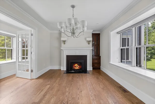 a view of a livingroom with a fireplace wooden floor and windows