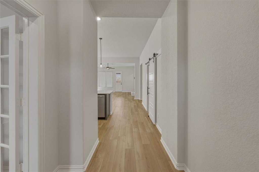 1213 Colca Drive Springtown, TX 76082 - Photo 5 of 23 Hallway featuring wood-finish flooring, white baseboards, and light-toned walls
