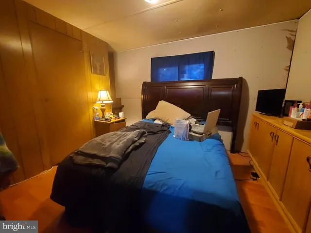 a bed sitting in a bedroom next to a window with pc on the wall