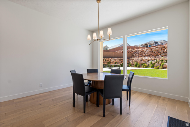1192 East Corral Way Washington, UT 84780 - Photo 18 of 81 Bright dining area featuring wood-finish flooring, white walls, and a contemporary chandelier