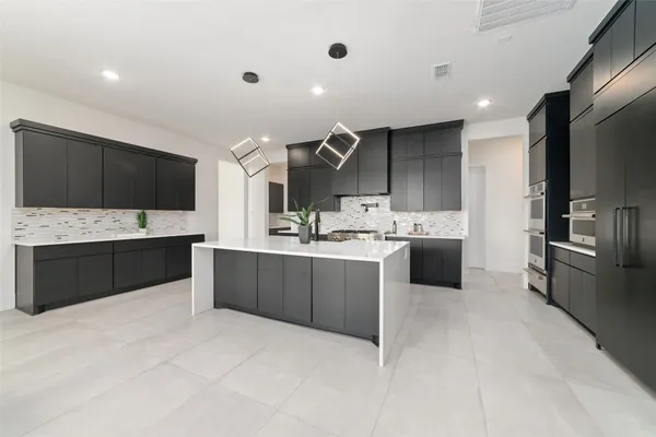 a large kitchen with a large counter top stainless steel appliances and cabinets
