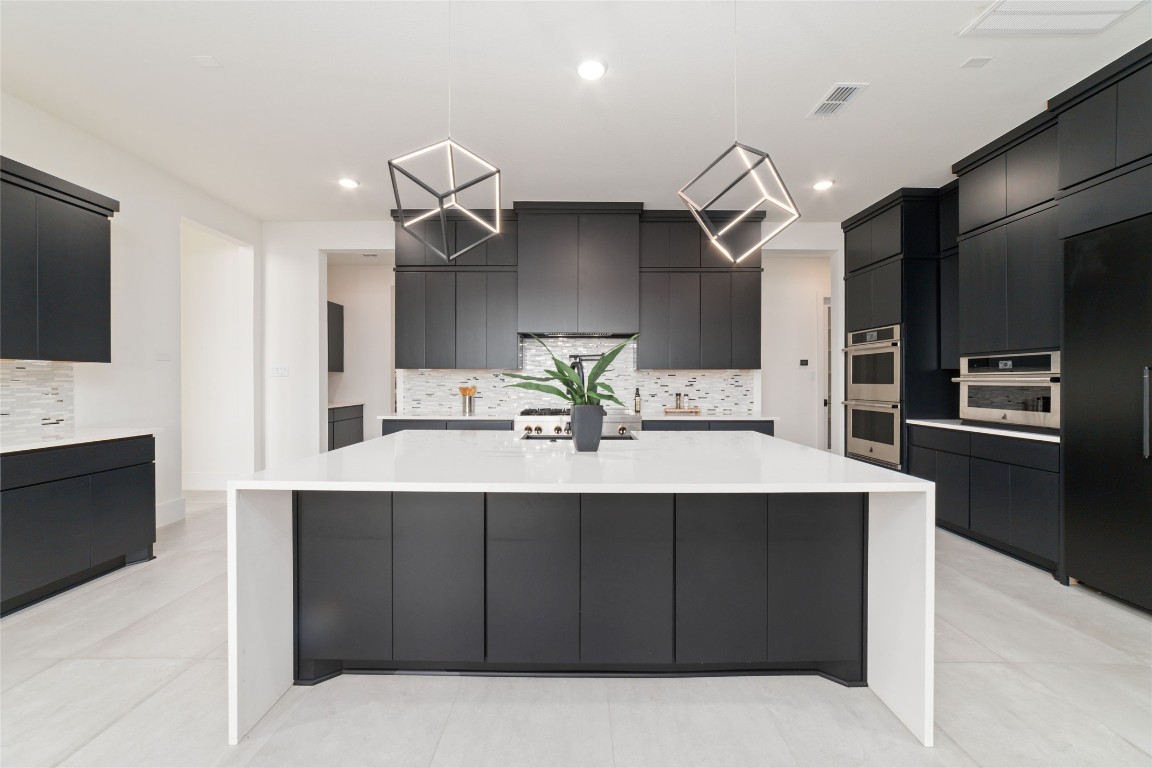 29627 Cir S Rnch Trail Fulshear, TX 77406 - Photo 15 of 50 A statement kitchen where design meets performance, anchored by a massive island and clean, modern lines.