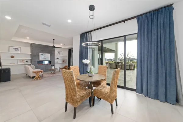 a dining room with furniture and a floor to ceiling window