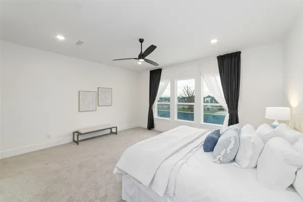 a bedroom with a bed and a large window