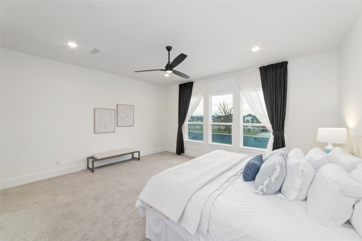 29627 Cir S Rnch Trail Fulshear, TX 77406 - Photo 23 of 50 Expansive first-floor primary suite with wide views of the pool and lake, built to feel like your own private retreat.