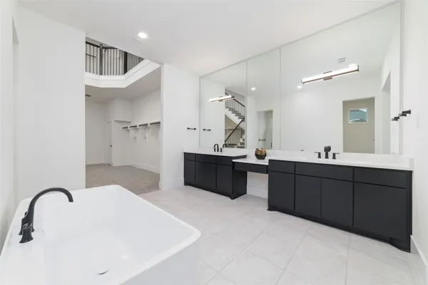 a spacious bathroom with a double vanity sink double mirror and bathtub