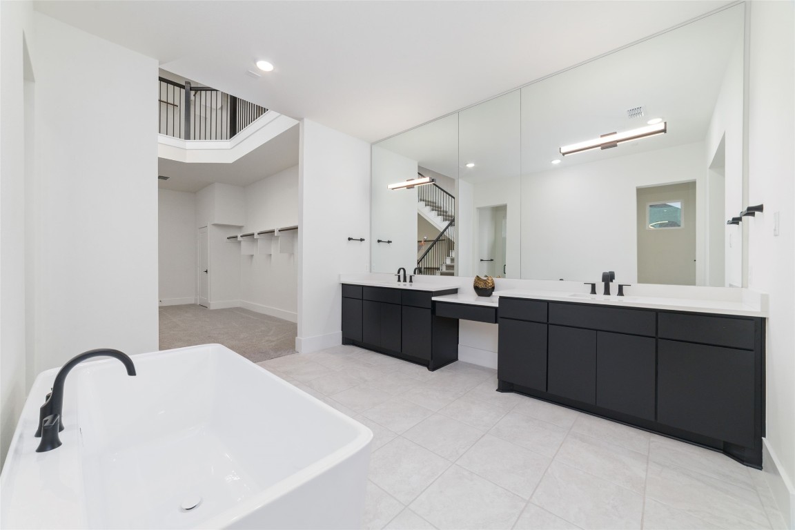 29627 Cir S Rnch Trail Fulshear, TX 77406 - Photo 24 of 50 Primary bath designed with clean symmetry and architectural balance, centered around a statement soaking tub with a dual-entry walk-through shower positioned just beyond, creating a true spa-level experience.