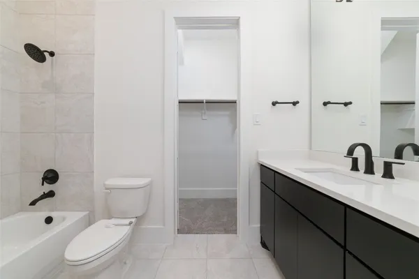 a bathroom with a granite countertop sink a toilet and shower