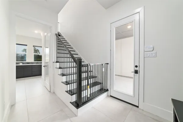 a view of a hallway with entryway and stairs