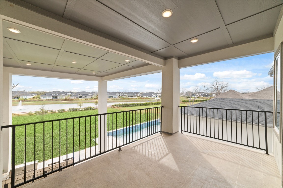 29627 Cir S Rnch Trail Fulshear, TX 77406 - Photo 34 of 50 Elevated balcony off of the upstairs gameroom, capturing long lake views and open sky, positioned for both quiet moments and evening resets.