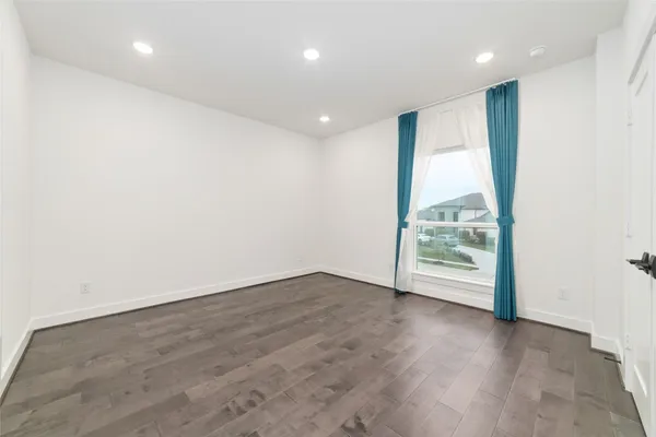 an empty room with wooden floor and a window