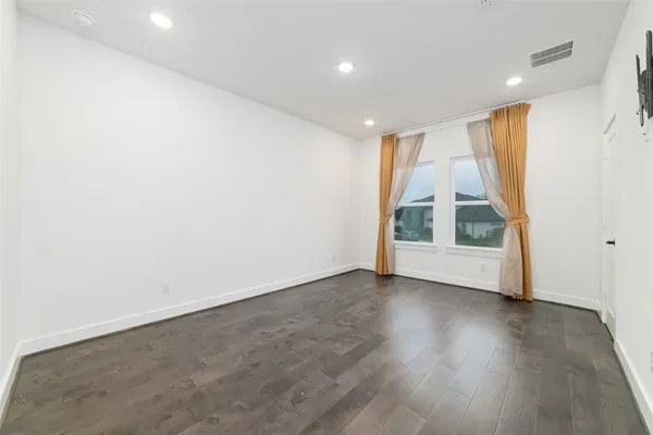 an empty room with wooden floor and window