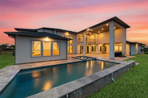 a view of a house with pool and sitting area
