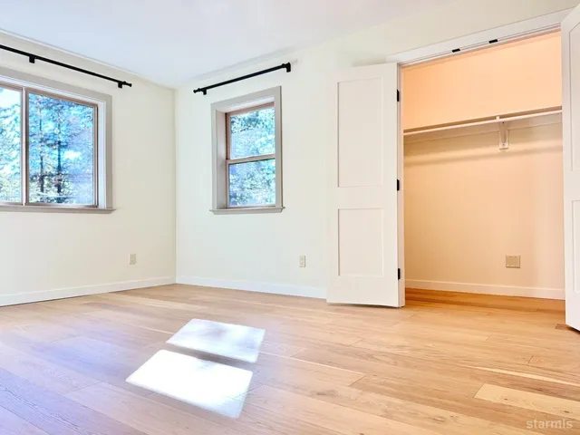 a view of a hallway with wooden floor and a living room