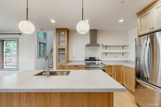 a kitchen with stainless steel appliances granite countertop a sink a stove and a refrigerator