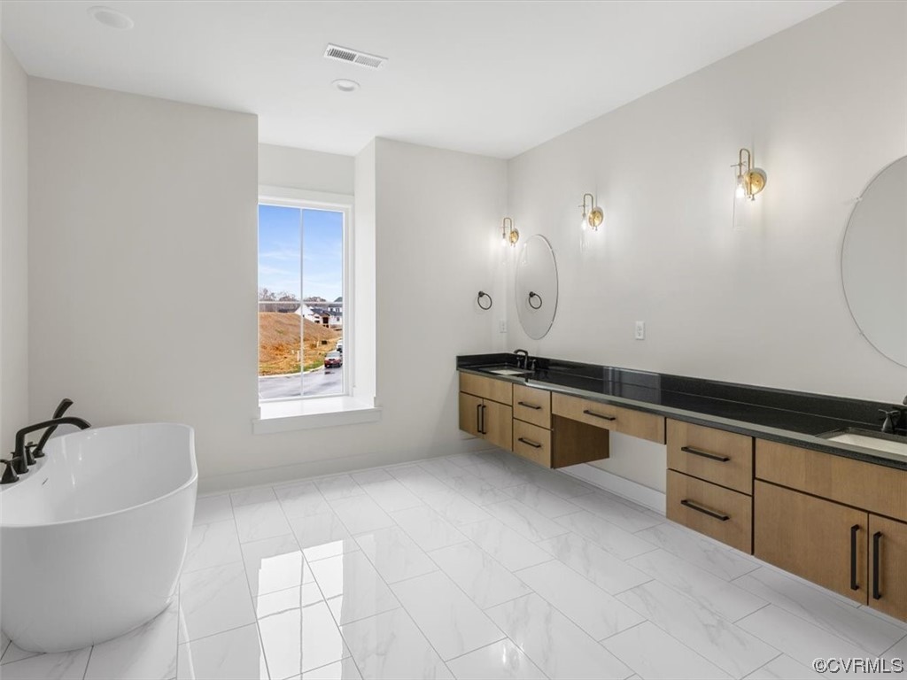10712 River Fall Path Glen Allen, VA 23059 - Photo 19 of 28 a spacious bathroom with a double vanity sink a mirror and a bathtub