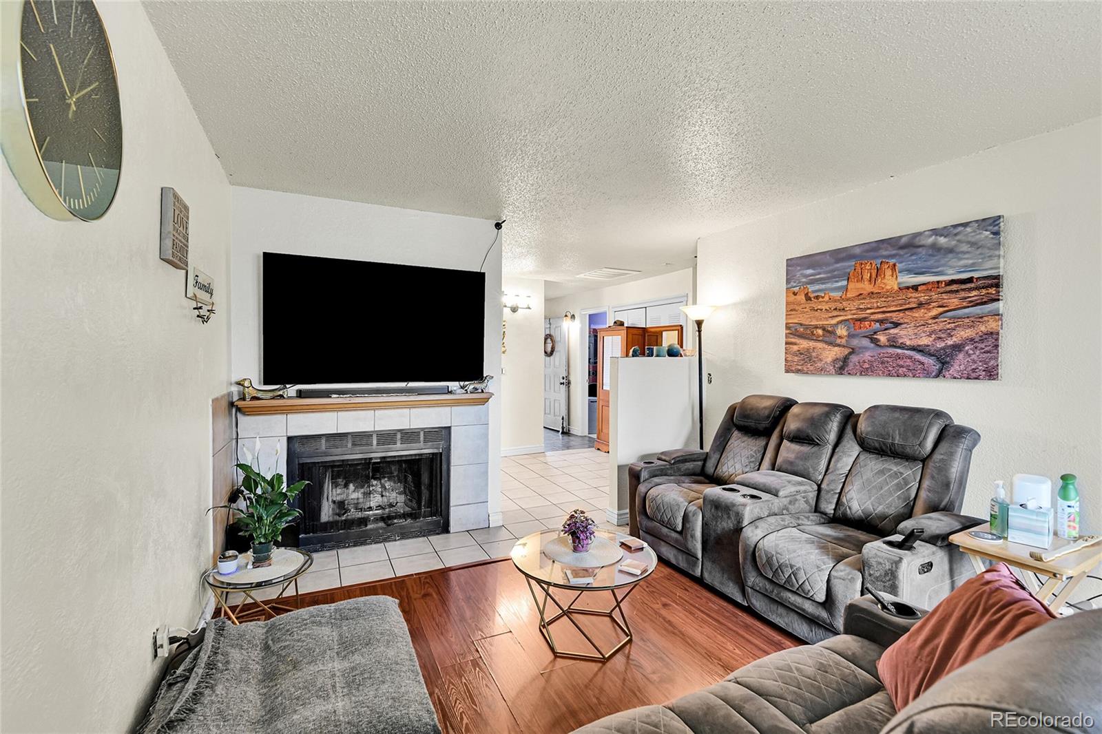 8470 Decatur Street, Unit 80 Westminster, CO 80031 - Photo 11 of 28 a living room with furniture a flat screen tv and a fireplace